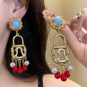 Detailed view of vintage enamel sun lock earrings featuring Bohemian long red beads