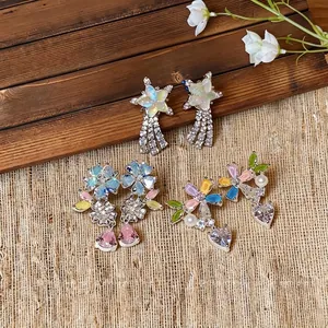 Set of three colorful floral and heart-shaped earrings with pearls and shiny zircons.