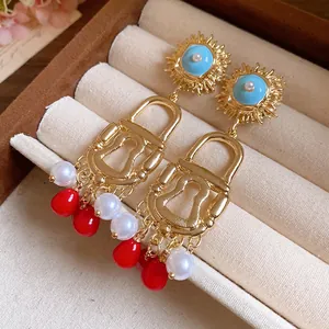 Close-up detail of bohemian vintage sun and lock earrings with colorful tassels