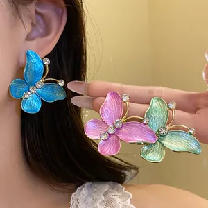 Close-up detail of colorful enamel butterfly stud earrings with sparkling zircon accents