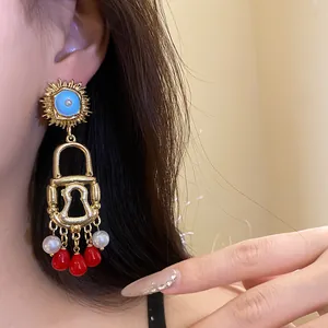 Detailed close-up of retro enamel sun and lock bohemian long drop earrings