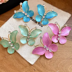 Colorful gradient enamel butterfly stud earrings with sparkling zircon accents on gold frames.