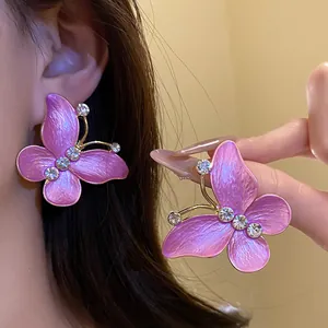 Detailed macro view of elegant pink gradient butterfly earrings with zircon stones