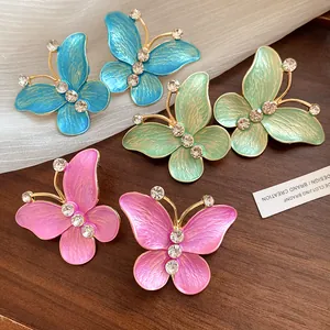 Detailed view of colorful gradient enamel butterfly earrings with sparkling rhinestones