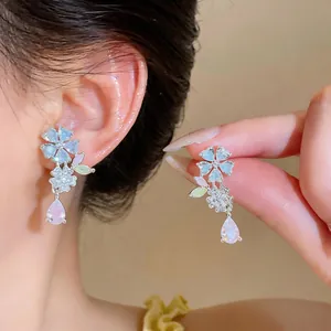 Close-up detail of sweet flower zircon earrings featuring a delicate pink teardrop pendant