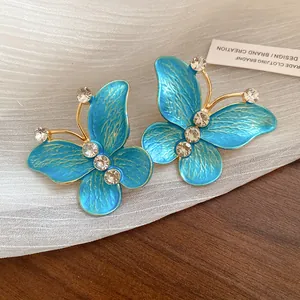 Close-up of vintage blue enamel butterfly earrings with sparkling zircon crystals