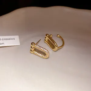 Dettaglio di orecchini a ferro di cavallo dorati con pavé di zirconi scintillanti