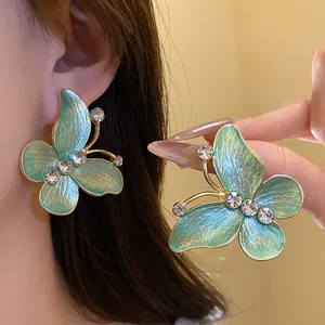 Detailed view showing gradient teal enamel butterfly earrings with sparkling zircons