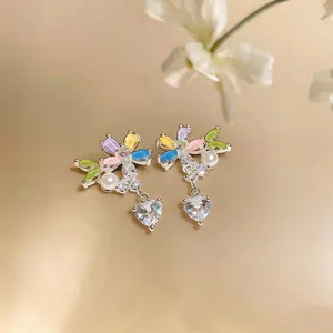 Close-up of sweet colorful flower heart earrings with cubic zirconia and pearls