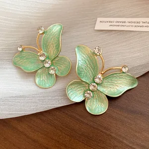 Close-up detail of mint green gradient butterfly earrings with sparkling zirconia