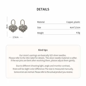 Detailed view of hollow heart drop earrings with copper material and size dimensions