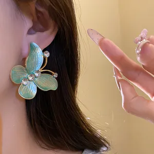 Detailed close-up of vintage butterfly stud earring with gradient enamel and clear zircons