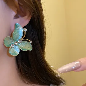 Close-up detail of a vintage gradient blue butterfly stud earring with sparkling zircons