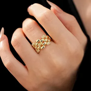 Anello ovale traforato multistrato con zirconi scintillanti su fascia placcata in oro.