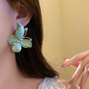 Detailed shot of vintage gradient enamel butterfly earring with sparkling zircon studs.
