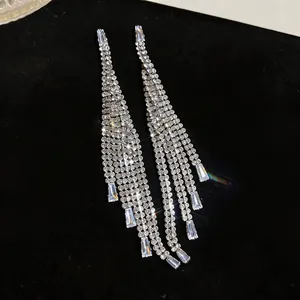 Close-up of silver-toned tassel earrings with shimmering cubic zirconia stones.
