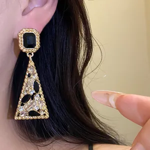 Detailed view of vintage triangle dangle earrings with black and clear rhinestones inlay
