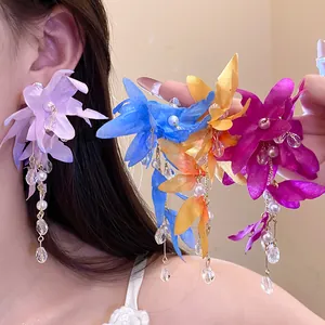 Detailed close-up of multi-colored fabric flower earrings with pearl tassels