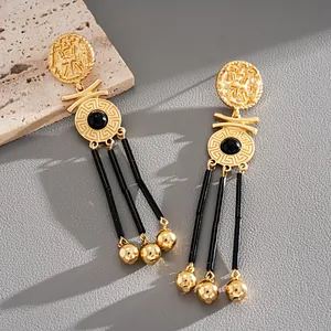 Detailed view of vintage gold coin dangle earrings with elegant black bead tassels