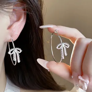 Elegant silver needle hoop earrings featuring pink enamel bow charm with zircon details