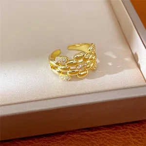 Primo piano di un anello multistrato dorato con pavé di zirconi su un vassoio.