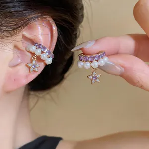 Detailed view of elegant star and pearl ear cuffs with purple crystals