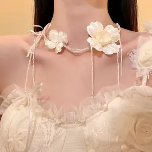 Primo piano di un'elegante collana girocollo floreale in tessuto bianco con perline