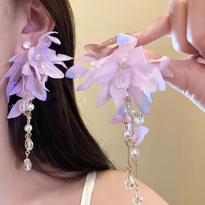 Detailed view of purple fabric flower earrings with elegant pearl and crystal tassels