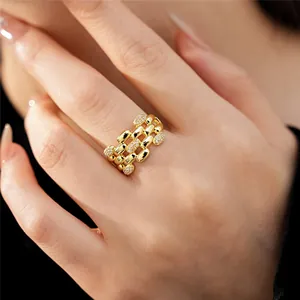 Dettaglio di un elegante anello in oro placcato multistrato con zirconi al dito
