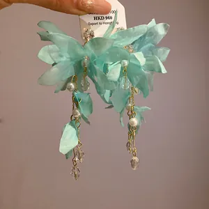 Close-up of cyan fabric flower earrings with elegant pearls and zircon tassels