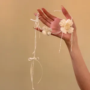 Primo piano di un elegante choker da sposa floreale bianco con nastro e perle