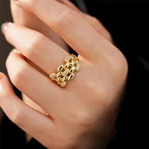 Dettaglio di un anello ovale dorato multistrato decorato con accenti in zircone