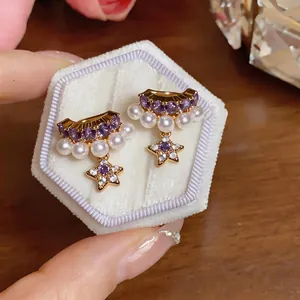 Close-up of elegant star and pearl ear clips with purple gemstones for non-pierced ears