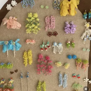Variété de boucles d'oreilles fleurs d'été colorées et de clous en perles sur un présentoir