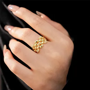 Primo piano di un anello ovale traforato a più strati in oro con zirconi brillanti