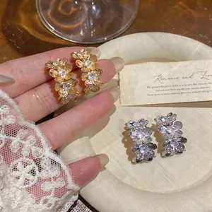 Elegantes pendientes de flores en oro y plata con cristales de circonita brillantes