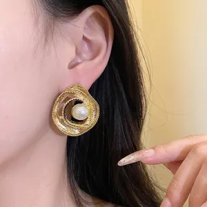 Vintage golden twisted circular stud earrings with elegant central pearl for women