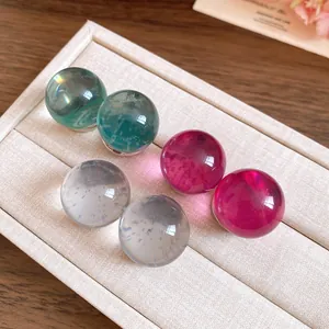 Detailed macro view of colorful round resin stud earrings on a jewelry tray