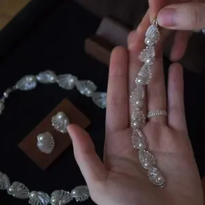 Vista detallada de un conjunto de joyas de conchas y perlas de estilo vintage francés