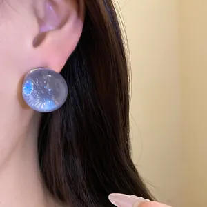 Detailed close-up view of a stylish lavender resin round stud earring on a model's ear