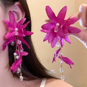 Detailed view of magenta fabric flower earrings with elegant pearl and crystal tassels