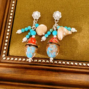 Vintage ethnic style tassel earrings with glass beads and pearl details on a retro frame