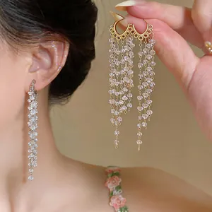 Detailed view of elegant gold and silver long tassel earrings with clear crystals