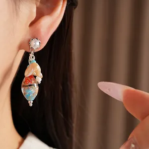 Close-up of vintage ethnic style earrings with colorful glass beads and pearl details