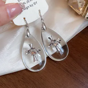 Dettaglio degli orecchini a goccia in acrilico con design a croce e cuore argento