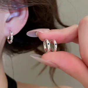Minimalist silver hoop earrings with blue zircon and starburst engraving