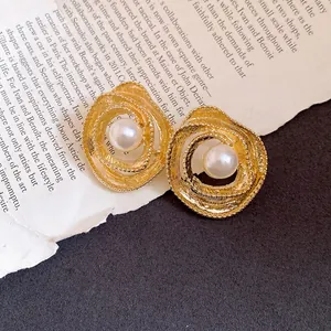 Vintage gold-toned circular wrapped stud earrings with central pearl detail.