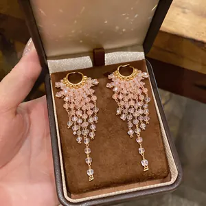 Detailed view of exquisite pink beaded tassel drop earrings in a luxury jewelry box