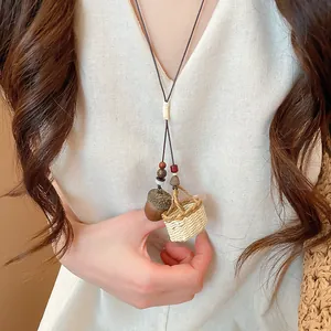 Macro view showing details of the unique acorn and mini woven basket pendant necklace