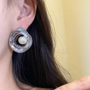 Elegant retro circular twisted silver earring featuring a central white pearl detail